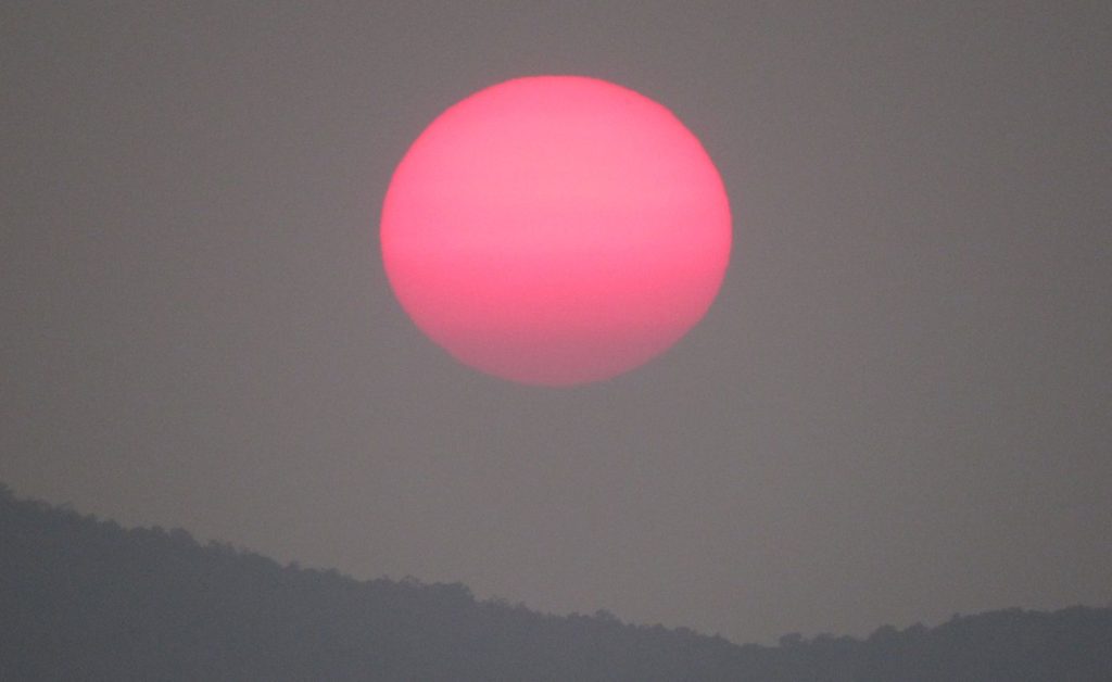 Glowing pink moon viewed from Pidurangala Rock, Sigiriya, Sri Lanka.